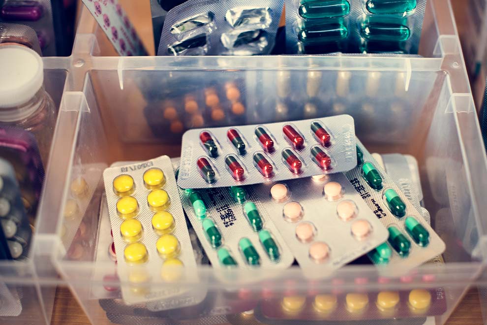 Caixa com diferentes tipos de medicamentos e cápsulas