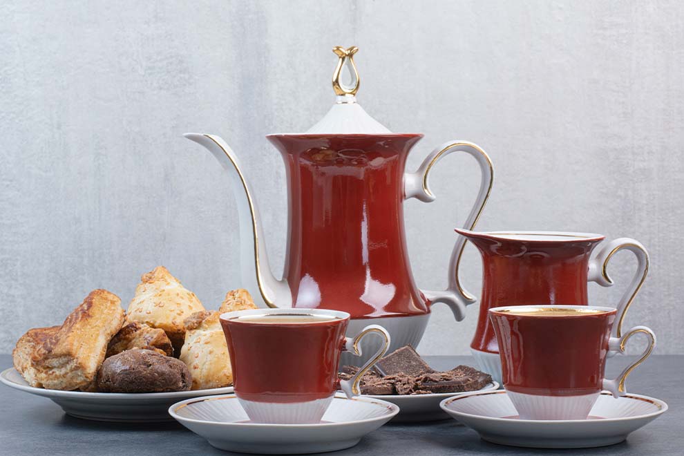 Conjunto de xícaras e bule com petiscos variados