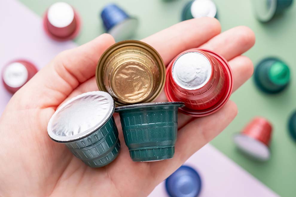 Mão segurando cápsulas de café coloridas