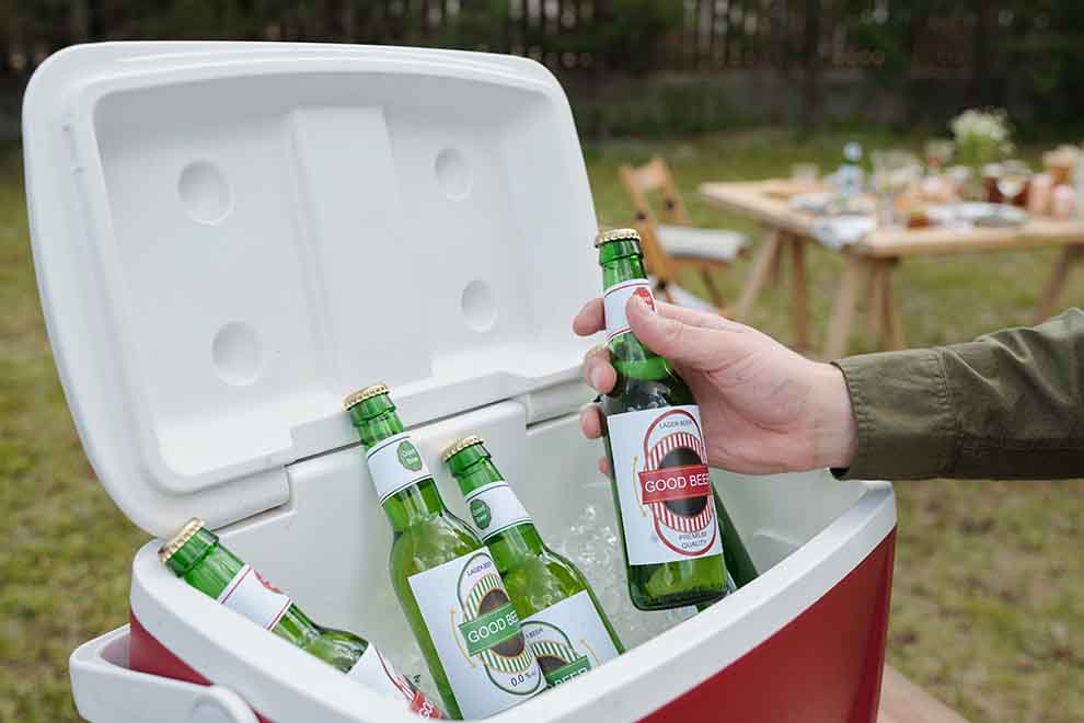 cooler com gelo e cerveja dentro em um churrasco em um dia ensolarado