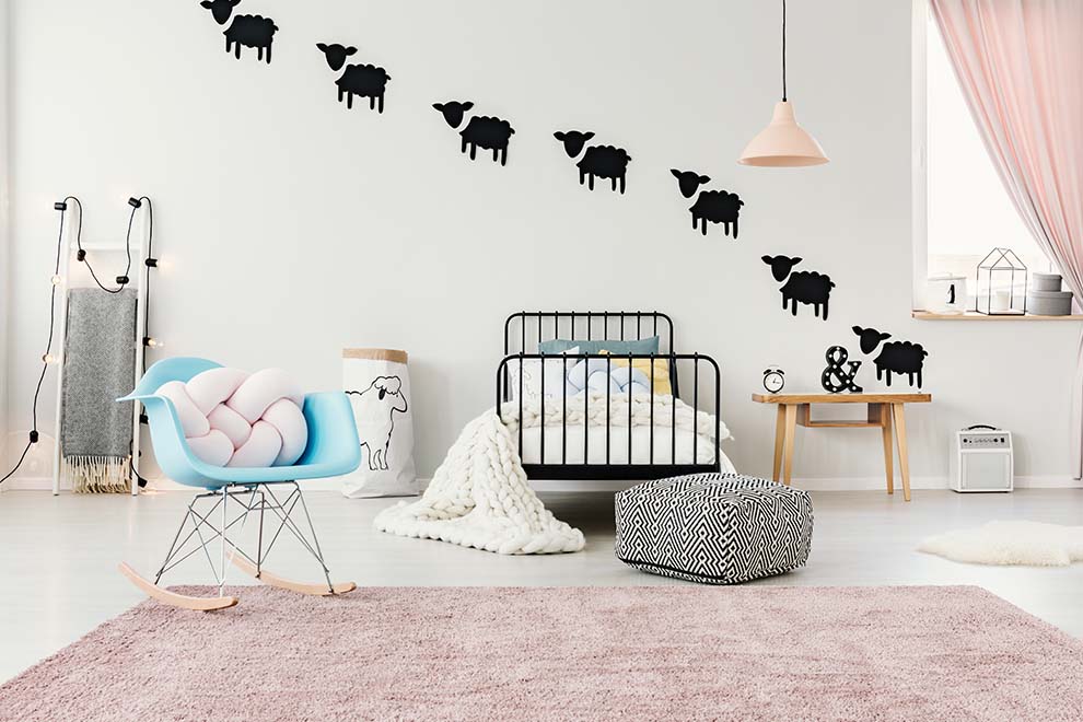 Quarto infantil com decoração de ovelhas e móveis modernos
