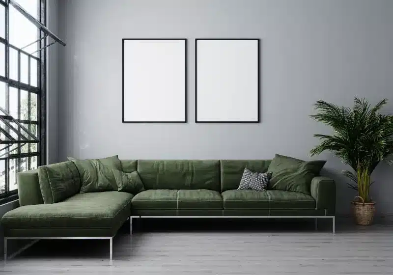 sala com sofá confortável e planta e quadro em branco na parede 