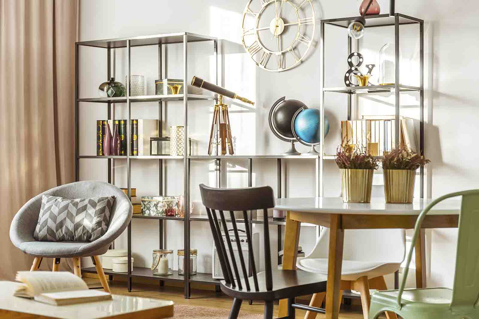 sala de estar com diversas cadeiras, mesa de jantar, uma estante modular e relógio de parede, durante o dia.