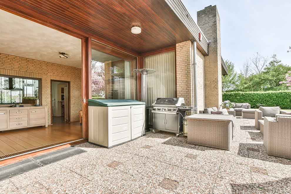 Área externa com churrasqueira e móveis de jardim