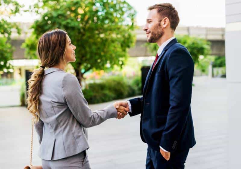 Uma mulher e um homem se comprimentando 