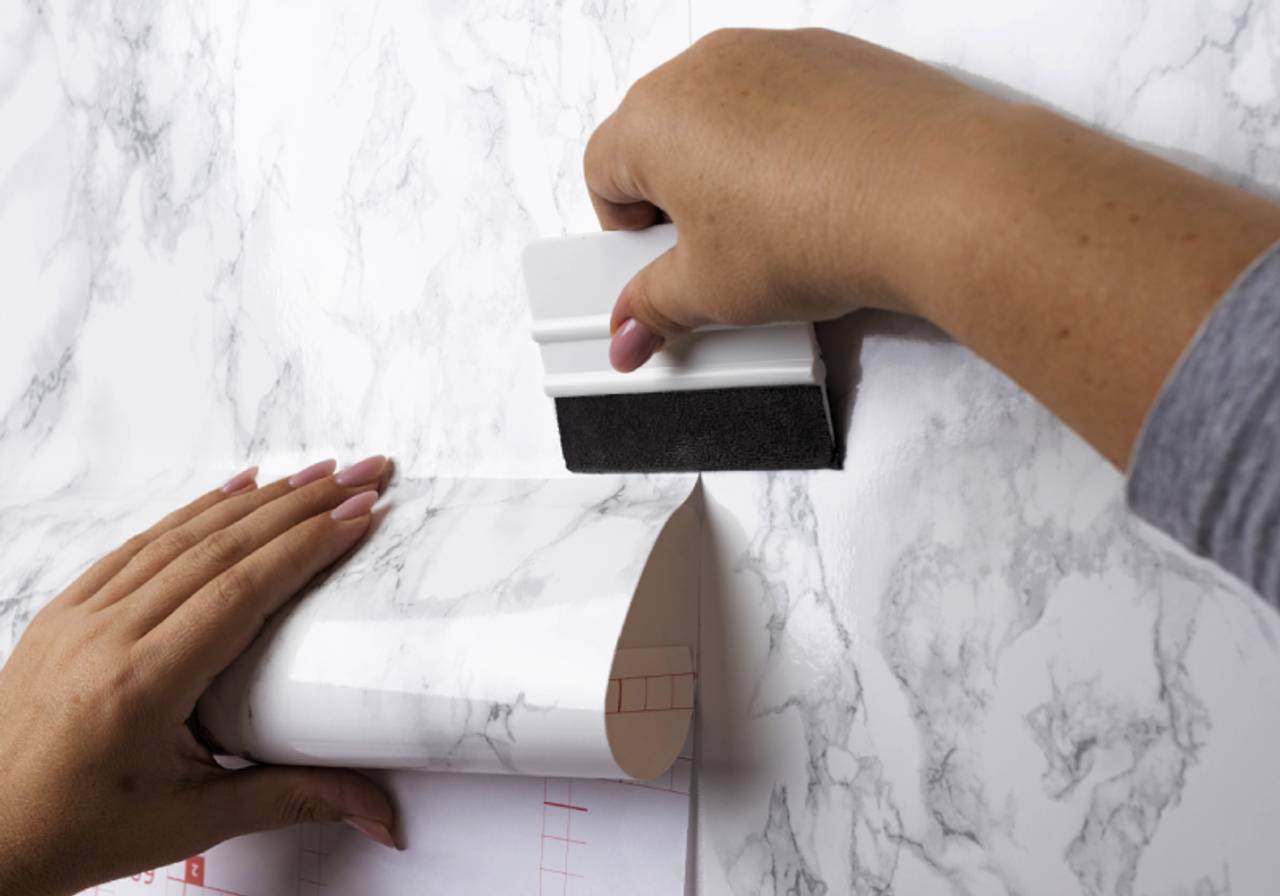 Pessoa aplicando papel de parede