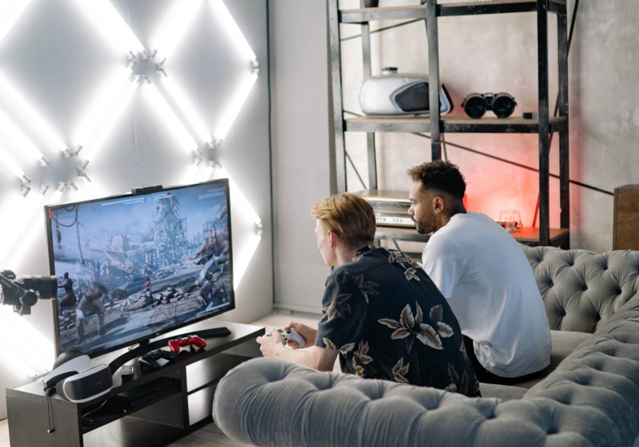 Duas pessoas sentados em um sofá jogando videogeme