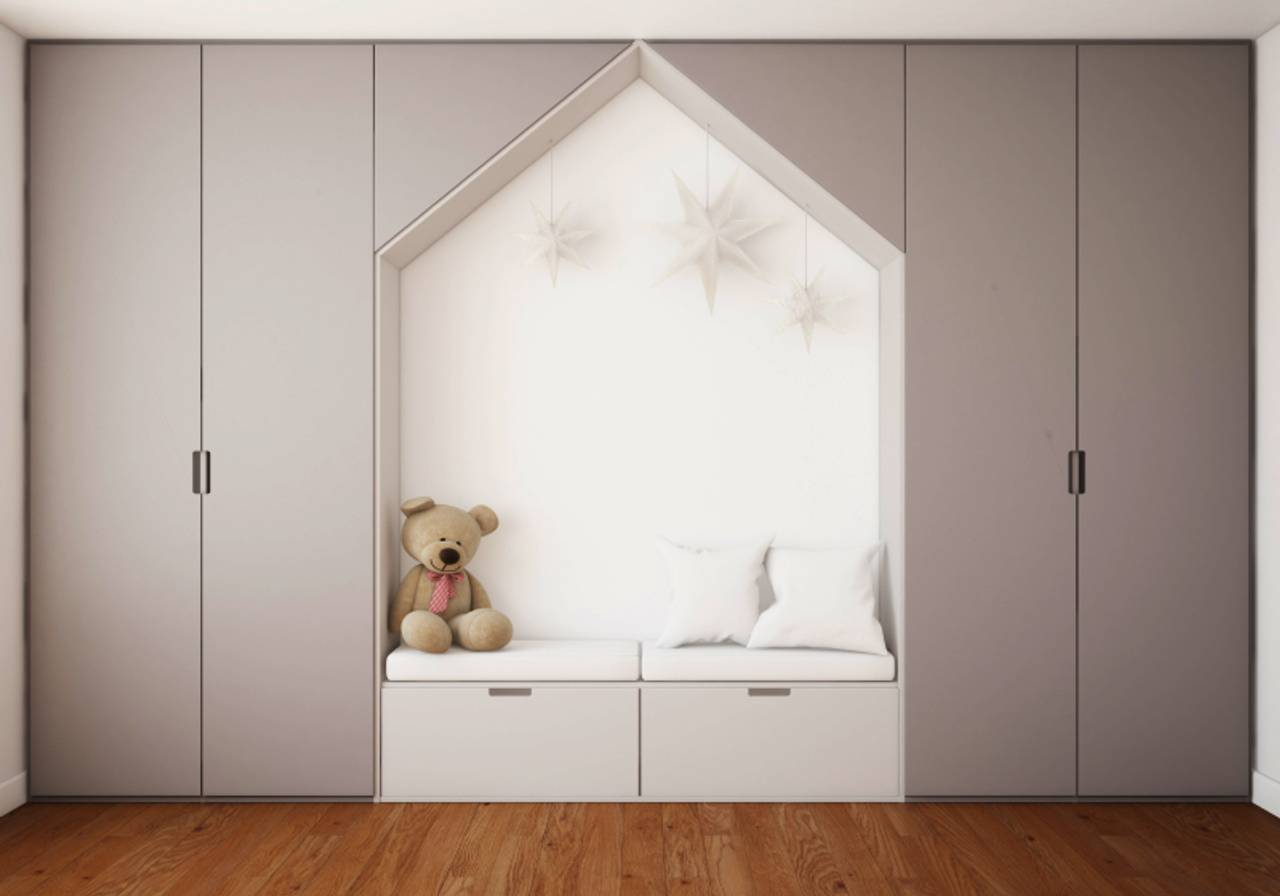 imagem de um quarto com guarda roupa e um urso de pelúcia em cima 