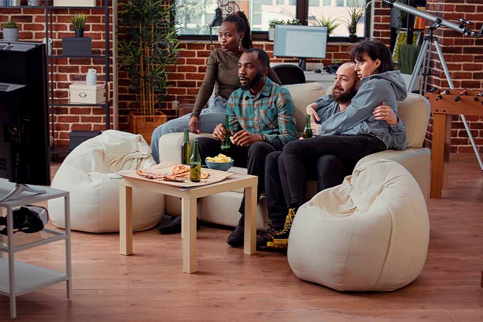Grupo de amigos assistindo TV e comendo pipoca