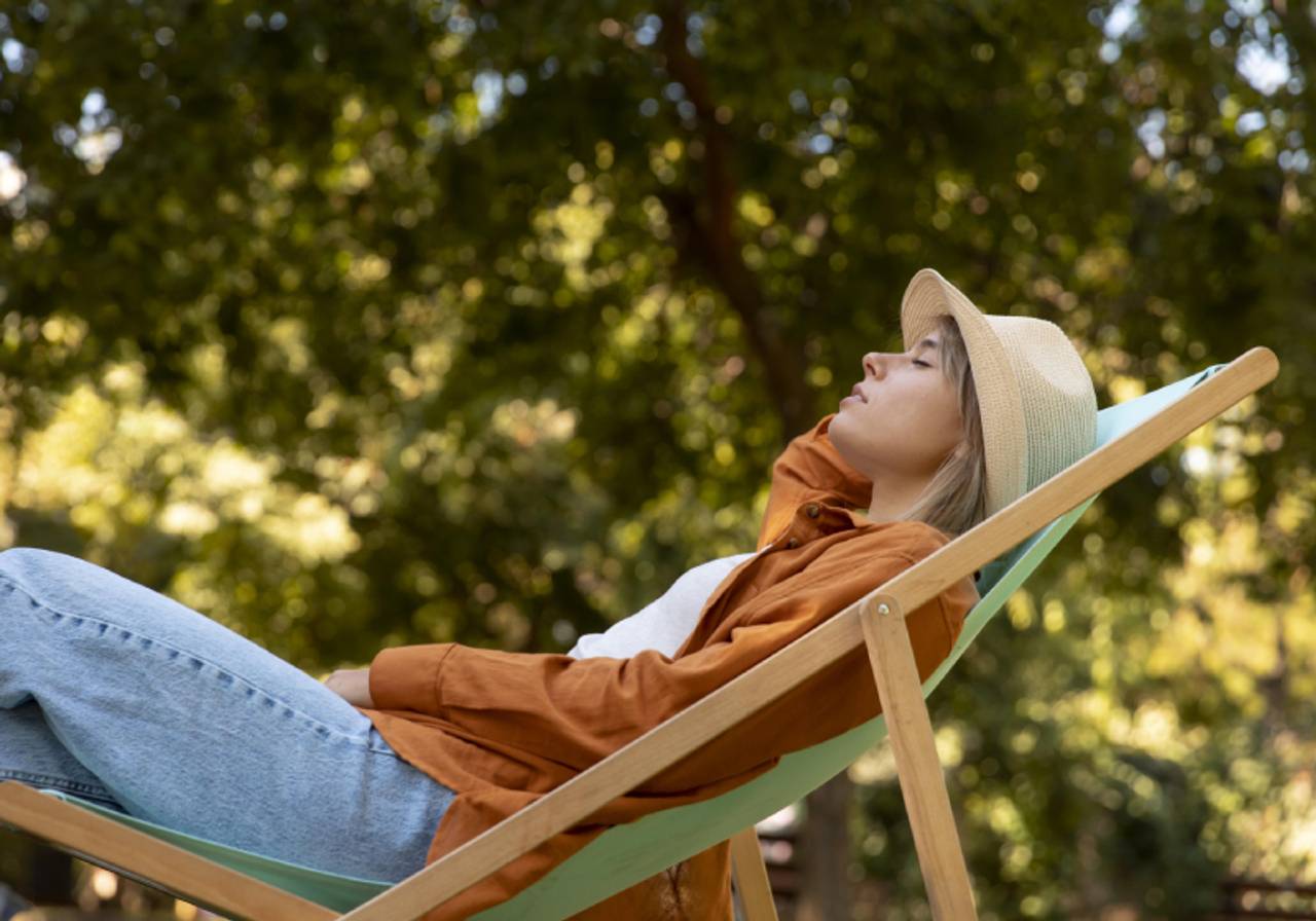mulher dormindo em cadeira de praia ao ar livre na natureza