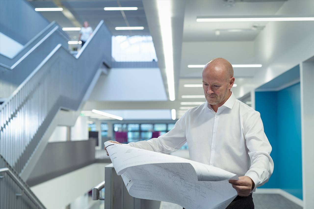 Pessoas analisando a planta de uma construção