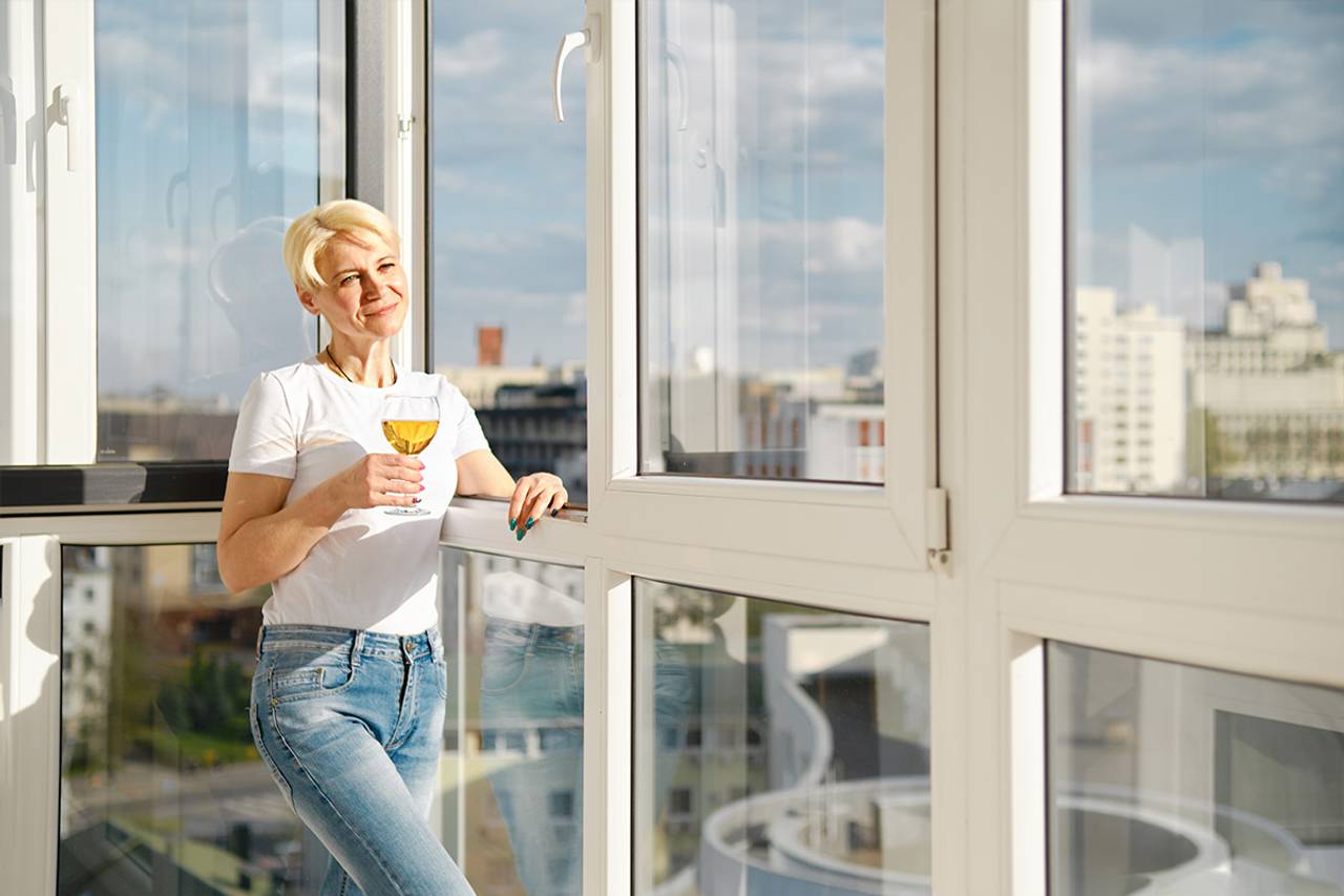 Mulher encostada na sacada do prédio