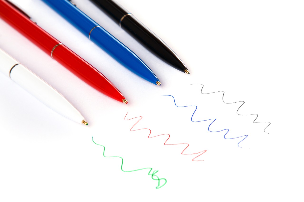 Quatro canetas uma de cada cor, preta, azul, vermelha e verde