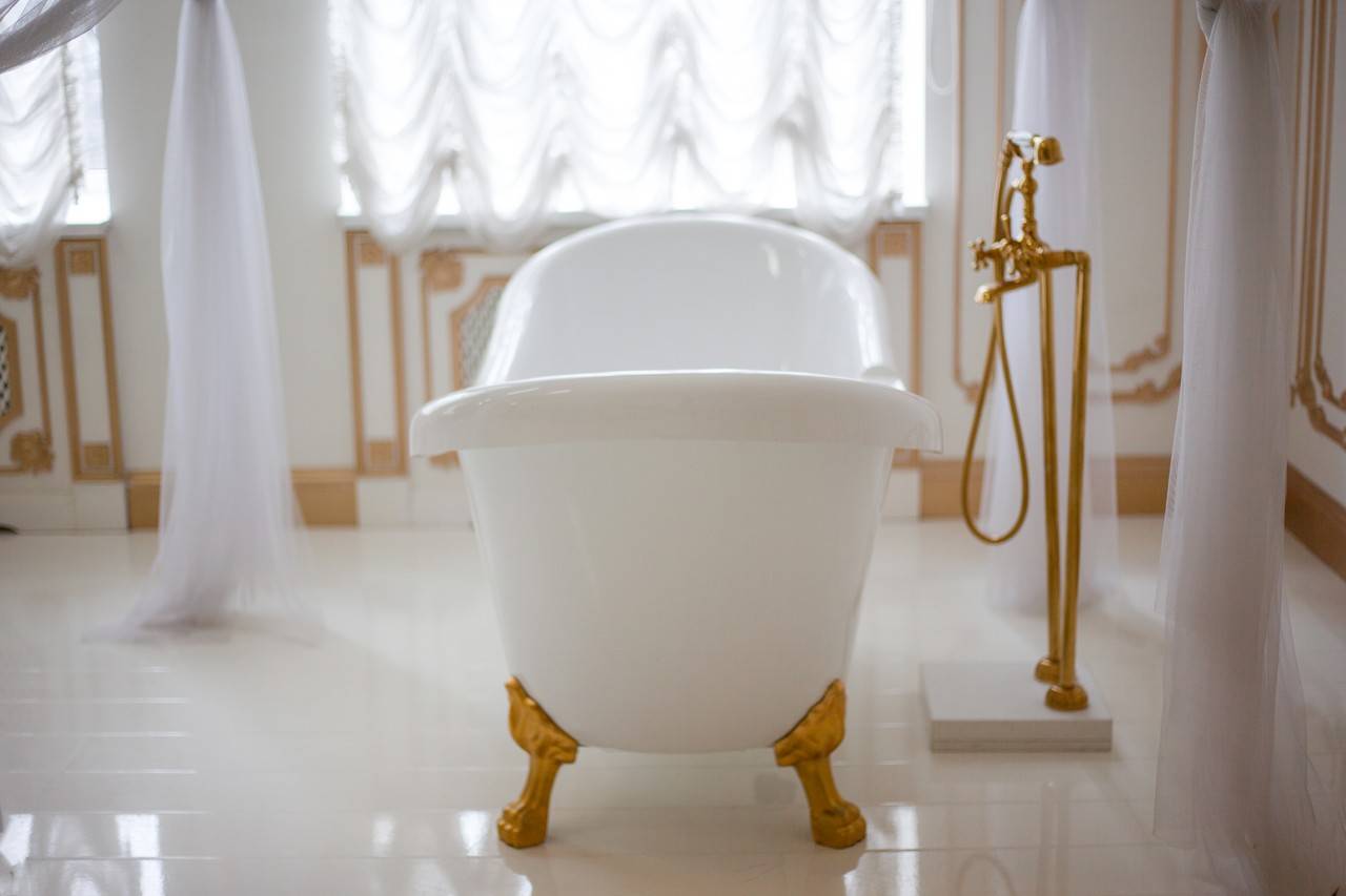 Banheiro com estilo barroco em tons de branco e detalhes de dourado