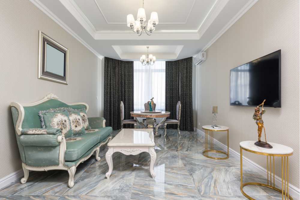 Sala com tom claros um sofá verde-claro e dois lustres de seis pontos de luz