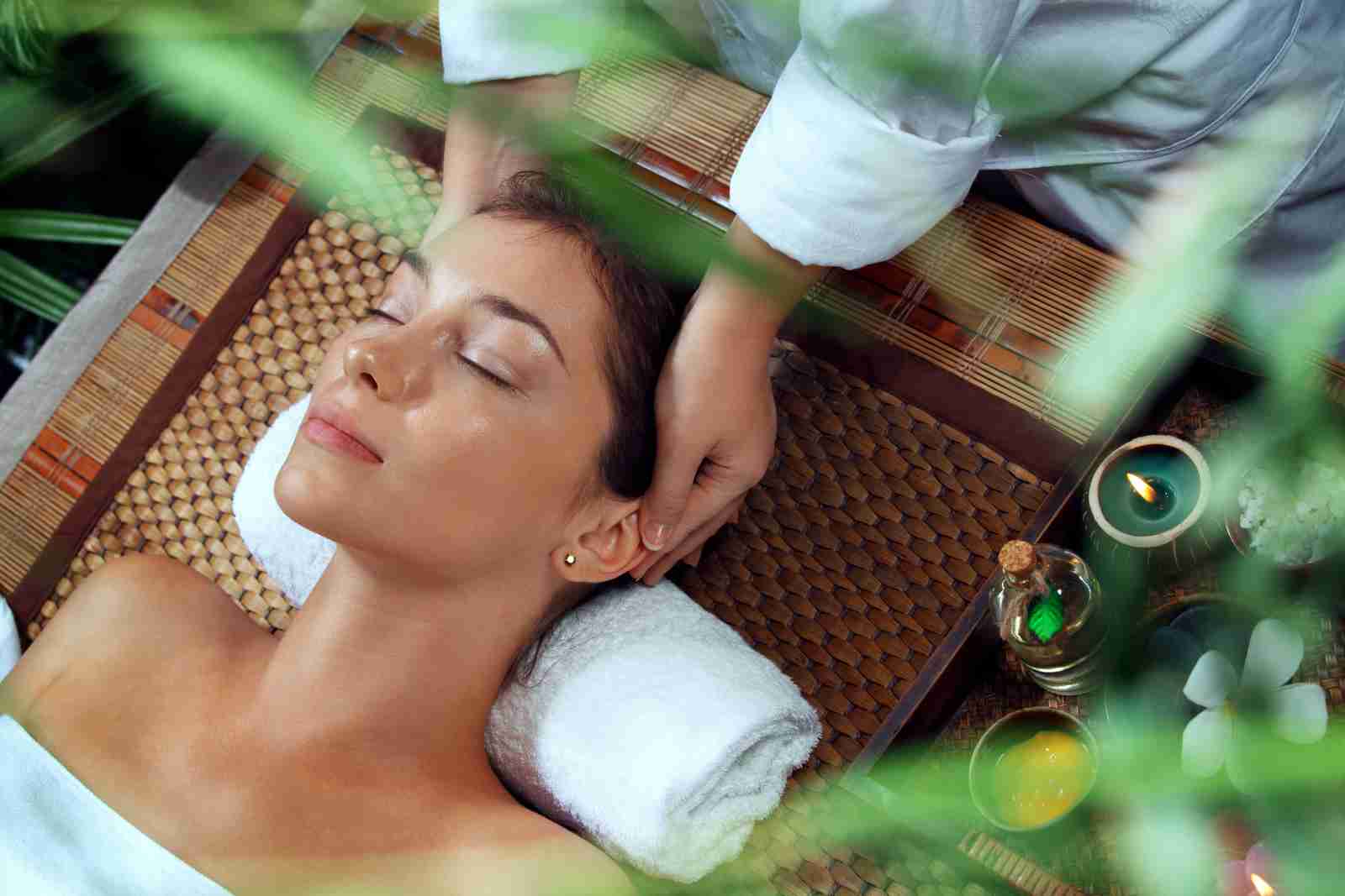 Mulher em um spa recebendo uma massagem na cabeça.