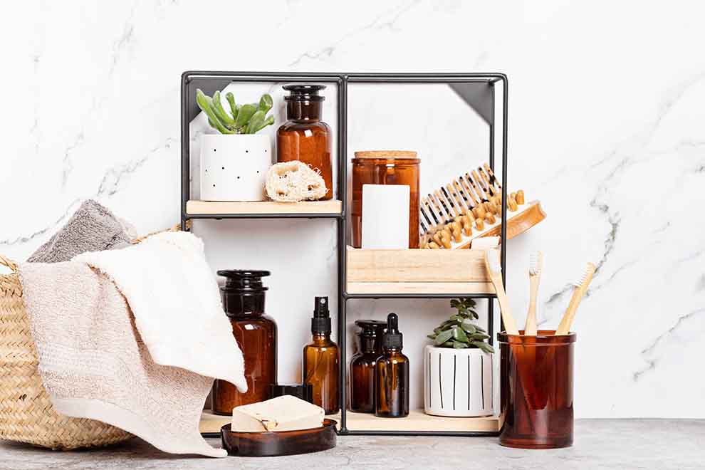 Organizadores de banheiro com itens de beleza e higiene em um banheiro branco.