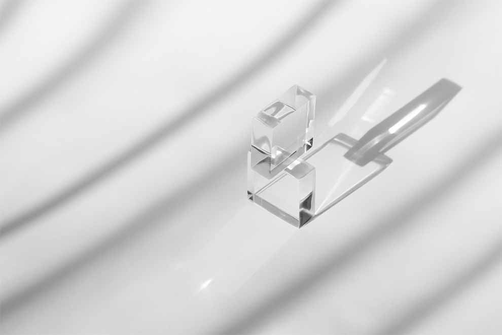 dois objetos quadrados de acrílico em cima um do outro com o fundo branco