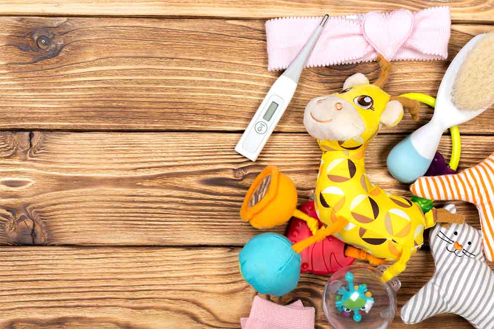 vários utensilios e brinquedos de bebê em cima de uma mesa de madeira