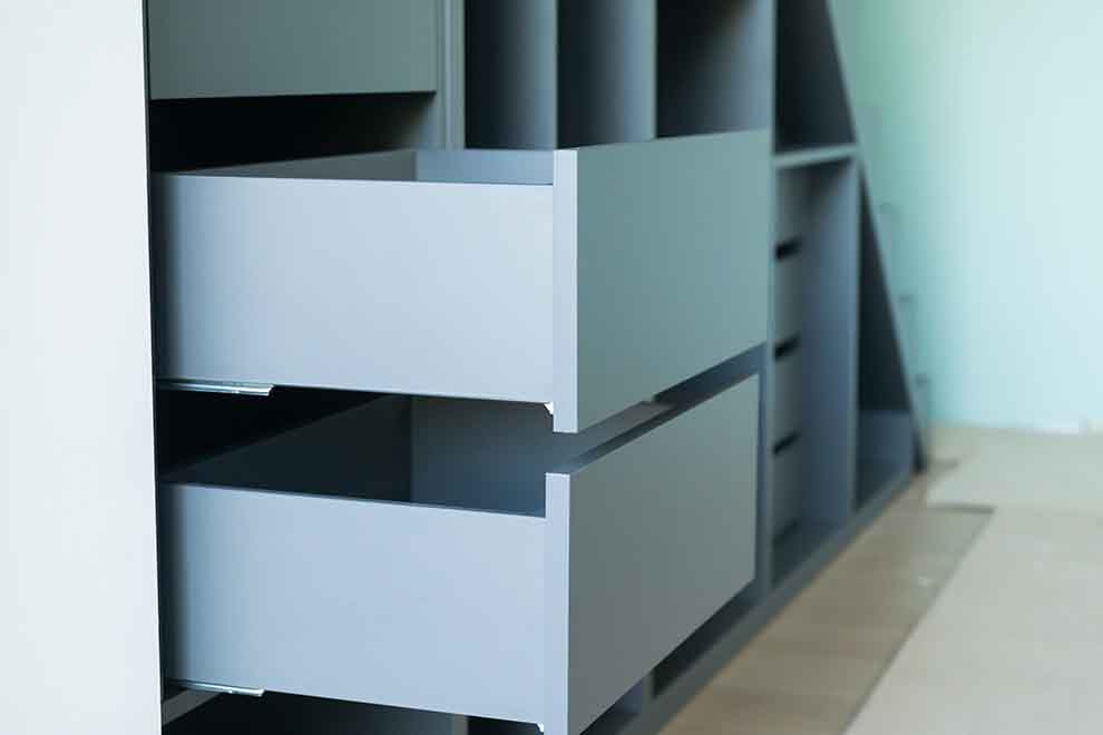 Gavetas abertas em móvel modular cinza