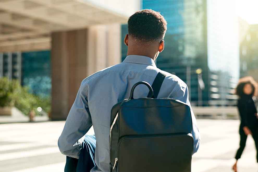 Homem de costas com mochila em ambiente urbano