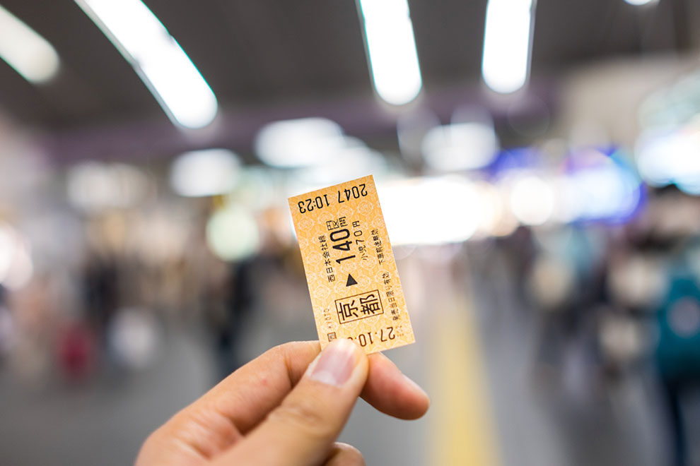 Início de viagem com passagem de trem nas mãos