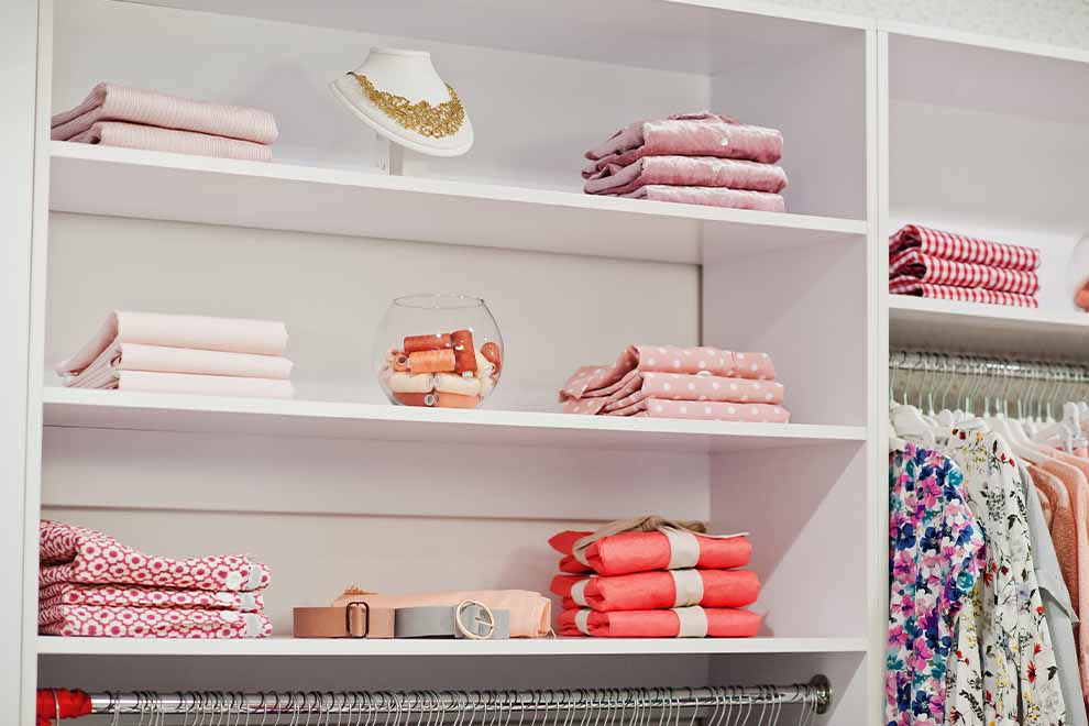 Prateleira com roupas em tons de rosa organizadas