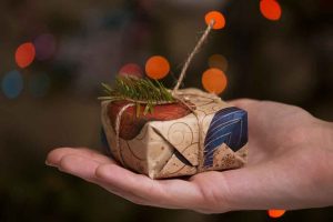 Presente de Natal decorado com ramos na palma da mão