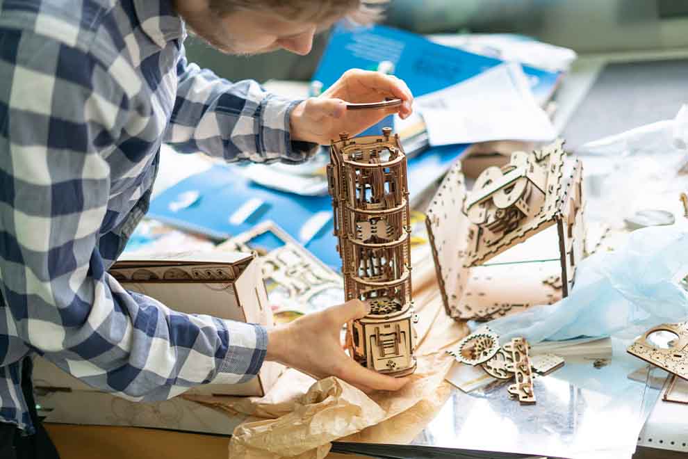 Adolescente montando jogo de madeira.