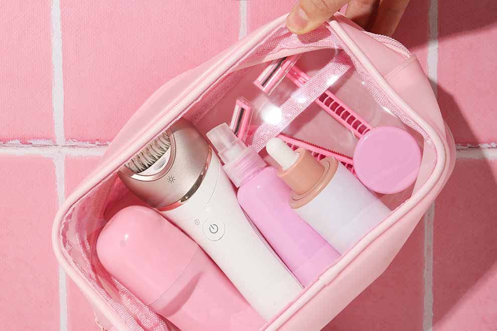 Uma bolsinha com kit de skincare e cuidados pessoais rosa claro e em um fundo claro.