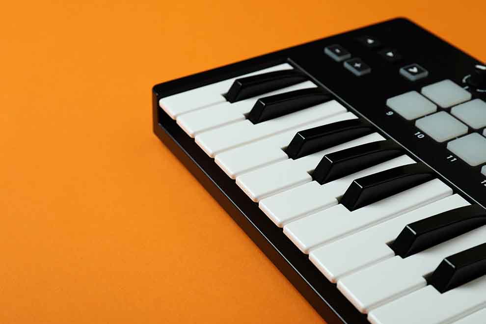 Mini teclado musical em um fundo laranja.